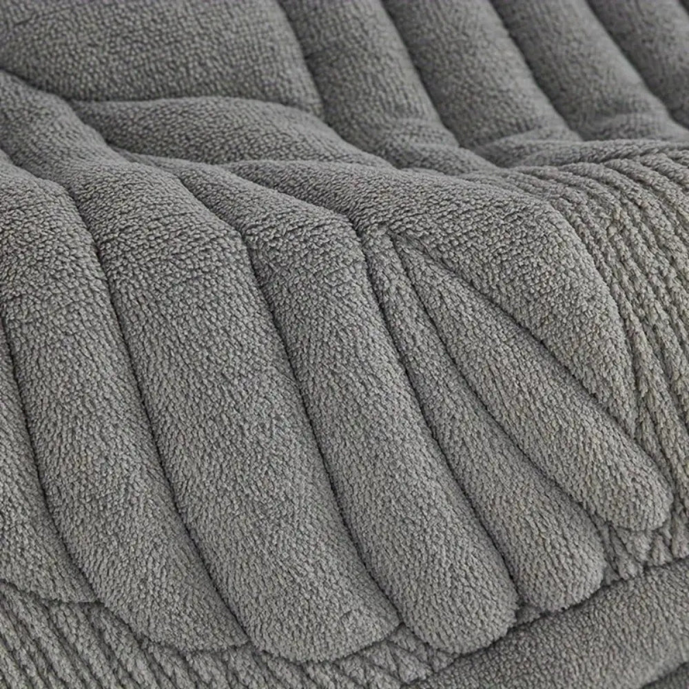 Close-up of a textured gray chair cover with plush, ribbed cushioning.