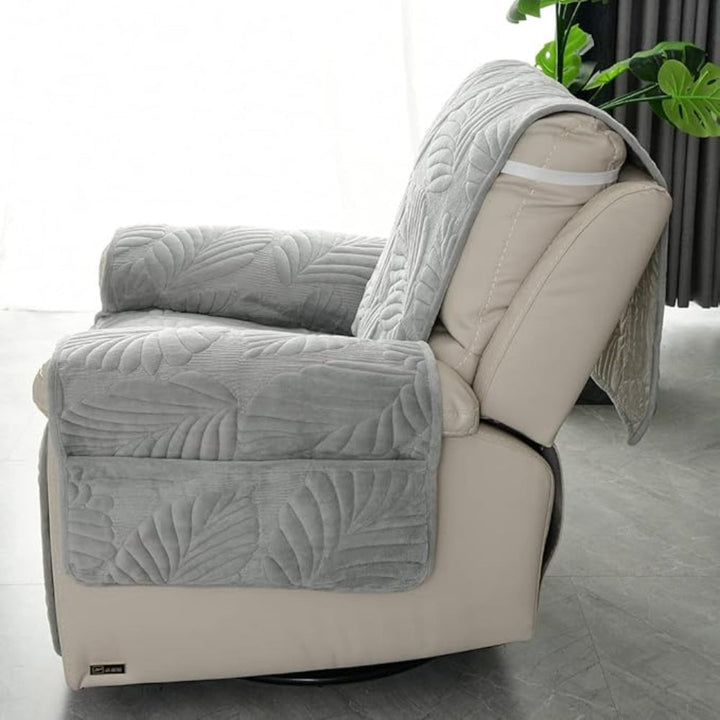 Gray leaf pattern recliner chair cover with armrest pockets and a draped back.
