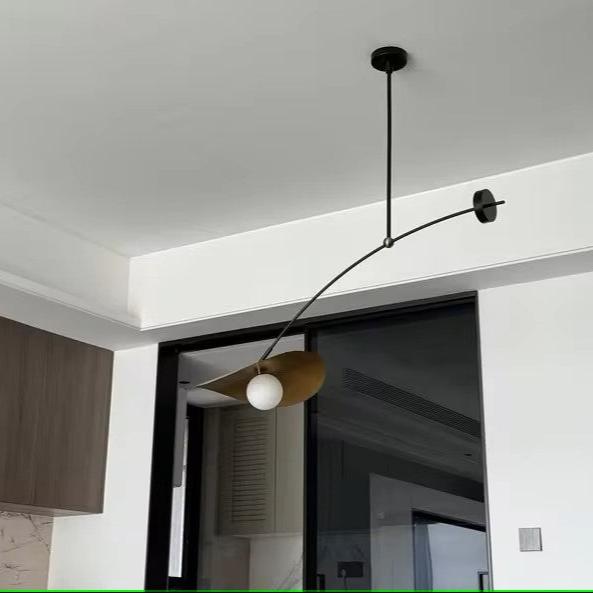 Black adjustable pendant light with a gold accent and white globe.