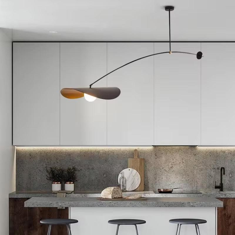 Black adjustable pendant light with a curved arm and a single light source over a kitchen island.