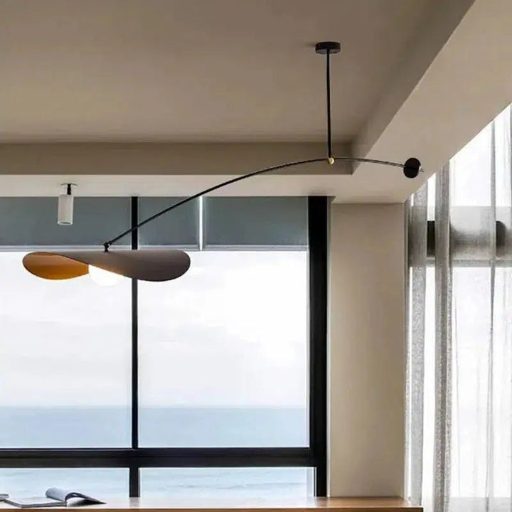 Black adjustable pendant light with a curved arm and two petal-shaped shades, one gold and one grey.