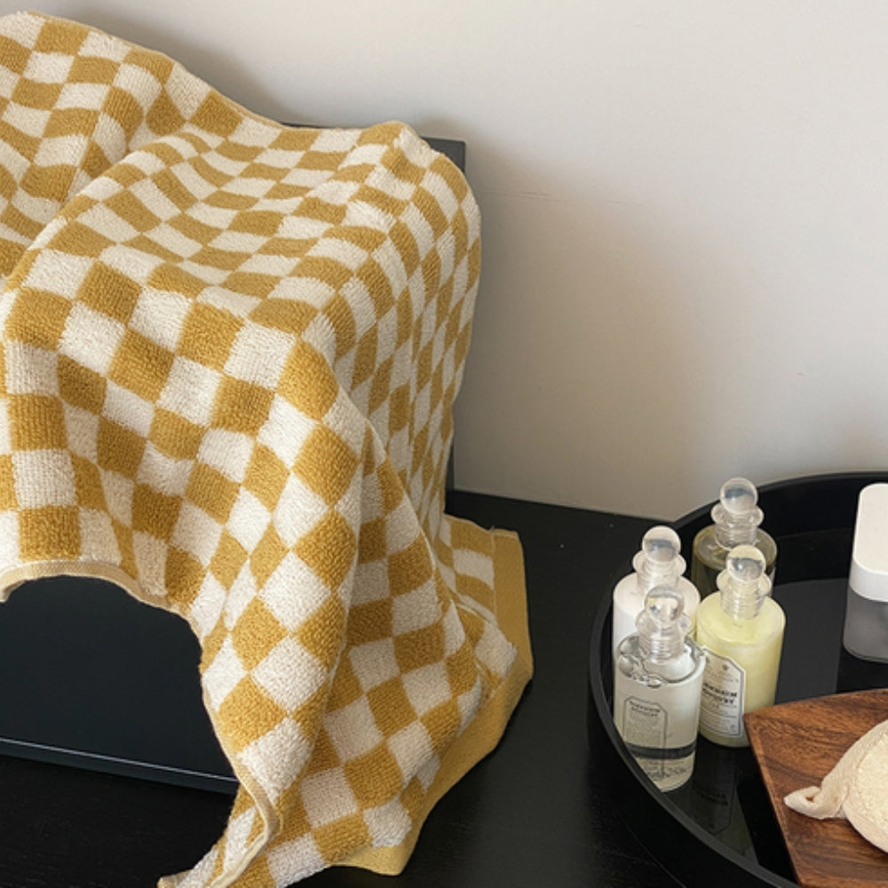 Yellow and white checkered cotton towel draped over a black surface.