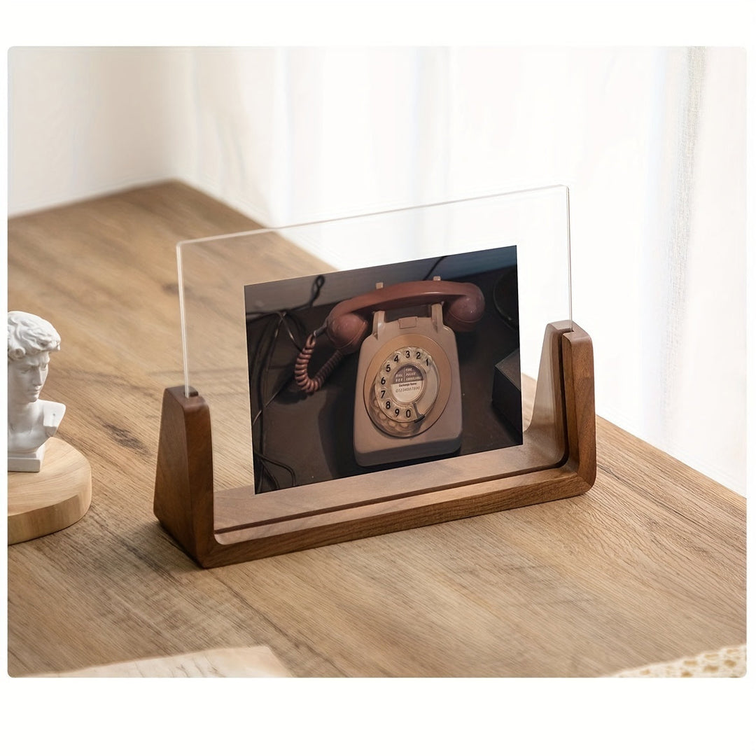 U-shaped acrylic photo frame with a wooden base displaying a vintage rotary phone.