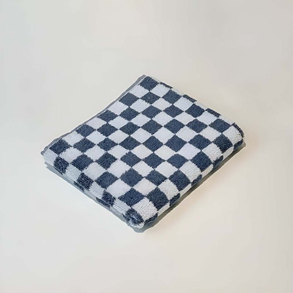 Blue and white checkered cotton towel folded on a white surface.