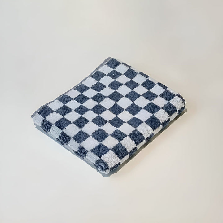 Blue and white checkered cotton towel folded on a white surface.