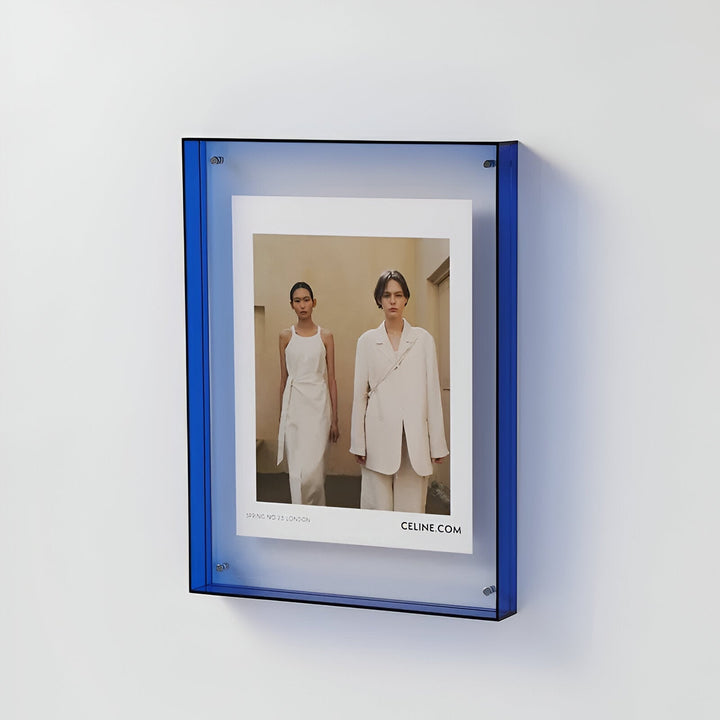 Blue acrylic picture frame displaying a fashion ad with two models.
