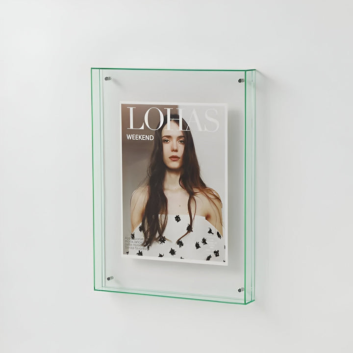A clear acrylic picture frame with green trim, displaying a magazine cover with a woman&