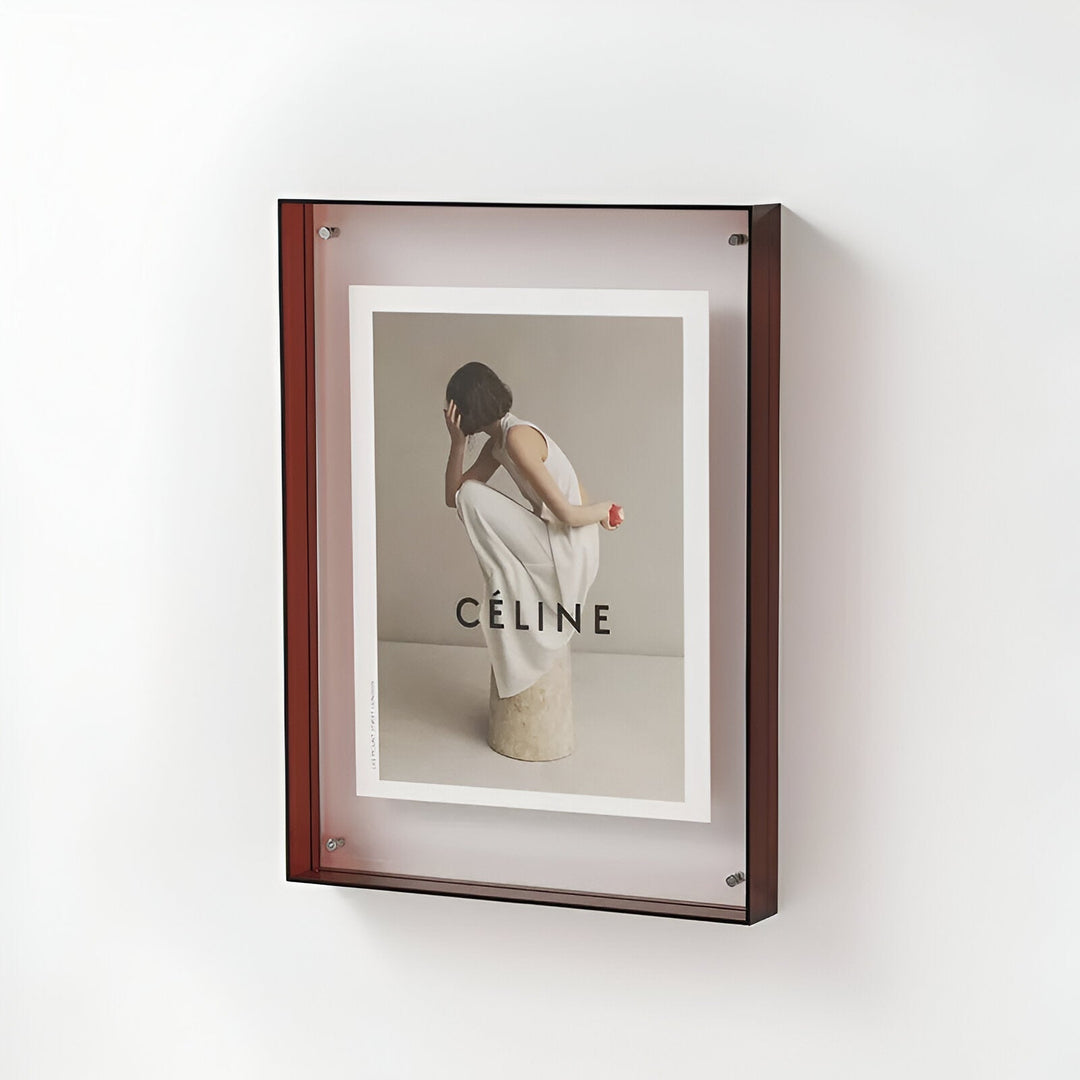 Brown acrylic frame displaying a Celine advertisement with a woman in white clothing.