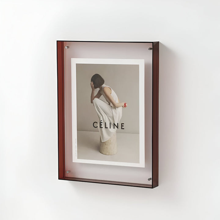 Brown acrylic frame displaying a Celine advertisement with a woman in white clothing.