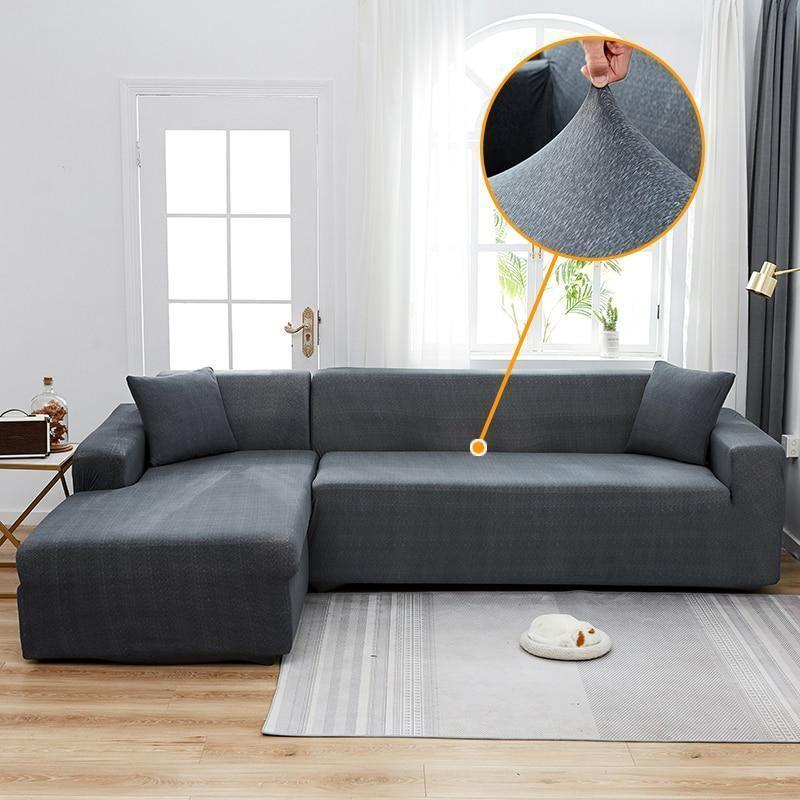 L-shaped anthracite grey spotted sofa cover shown on a sectional sofa with a close-up inset of the fabric's stretch.