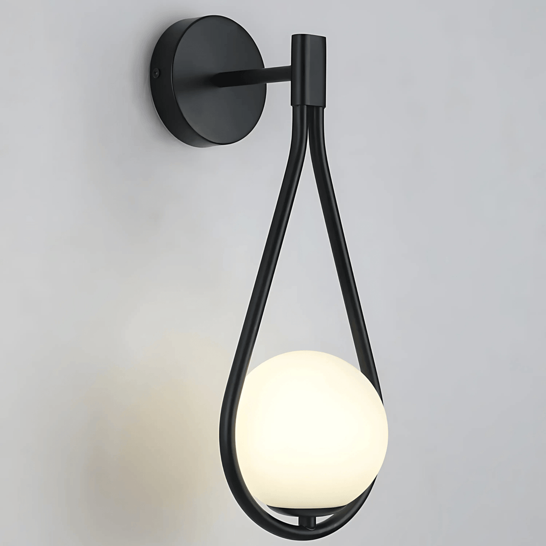 Black teardrop wall sconce with a glowing white orb light.