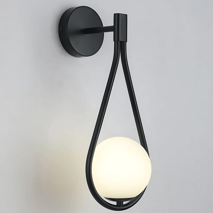Black teardrop wall sconce with a glowing white orb light.
