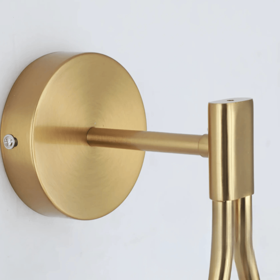 Brass wall sconce base with a horizontal arm extending to a vertical fixture.