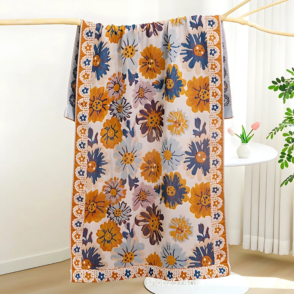 Reversible cotton bath towel with a vibrant floral print in blue, orange, and yellow on a light background.