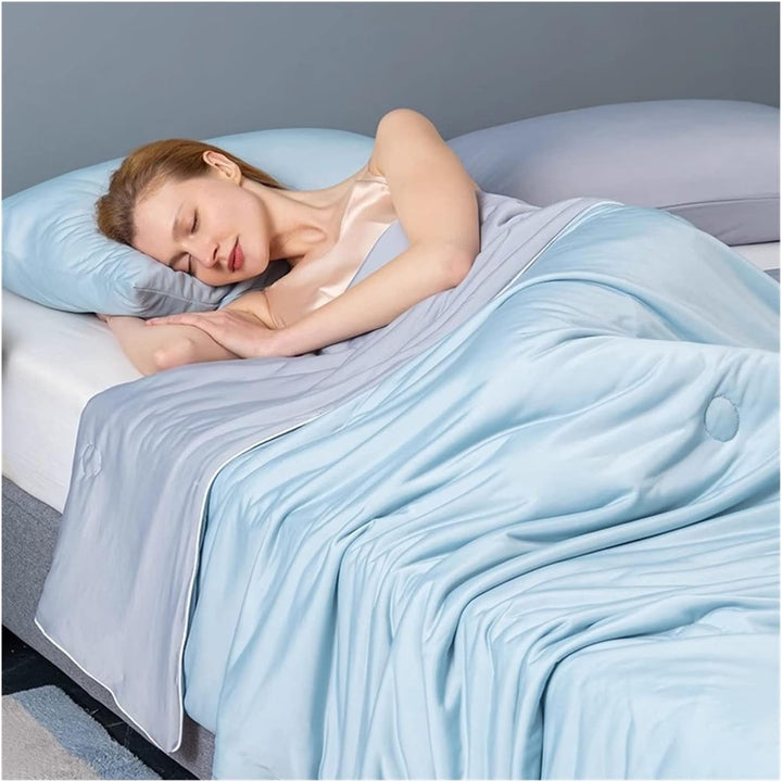 Woman sleeping under a lightweight, blue Forevercool cooling blanket.