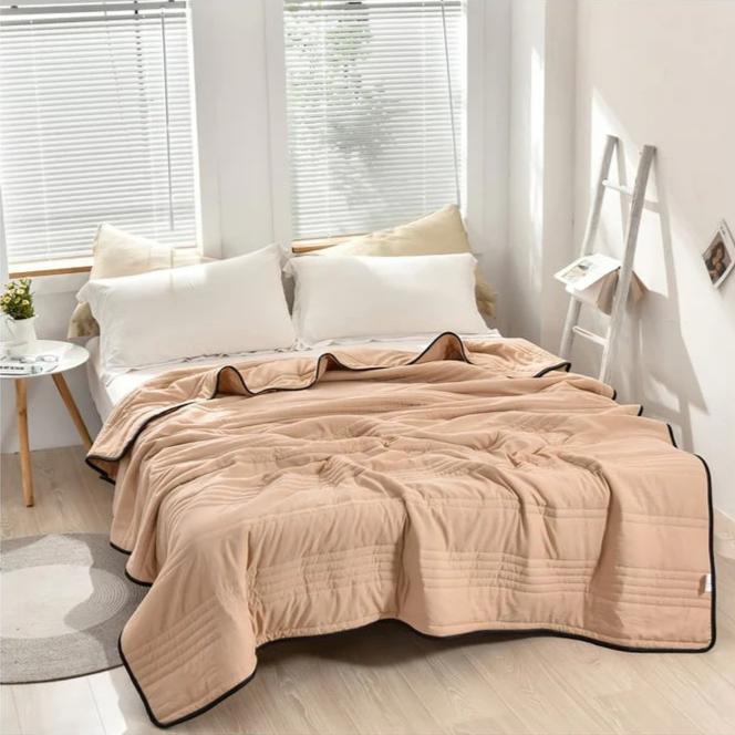 A beige EverChill Ice Cooling Blanket is spread across a bed with white pillows.