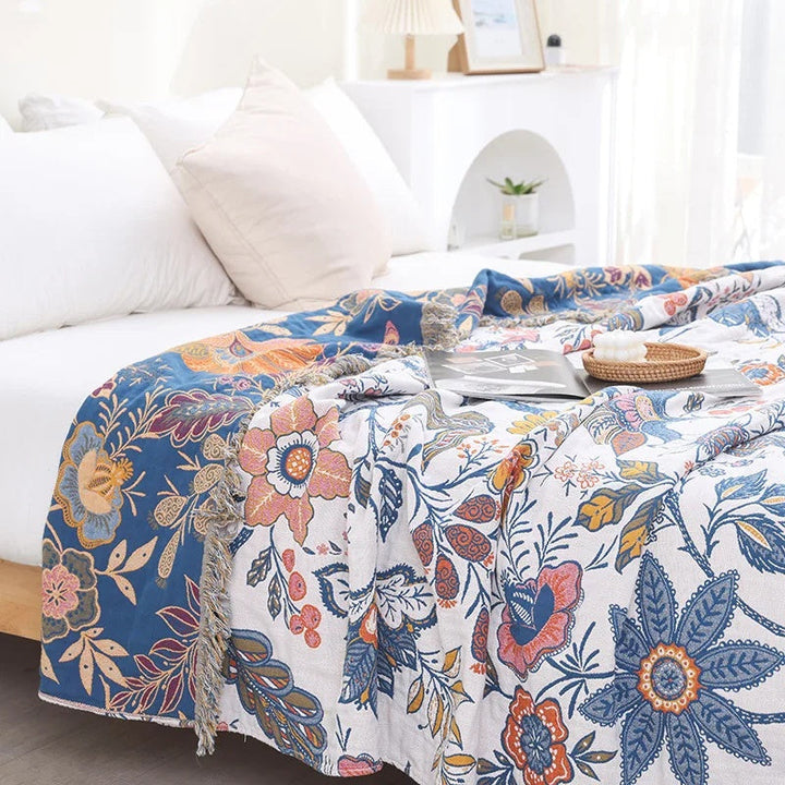 Rustic artistic flora cotton blanket with blue and white floral patterns and fringe detail.
