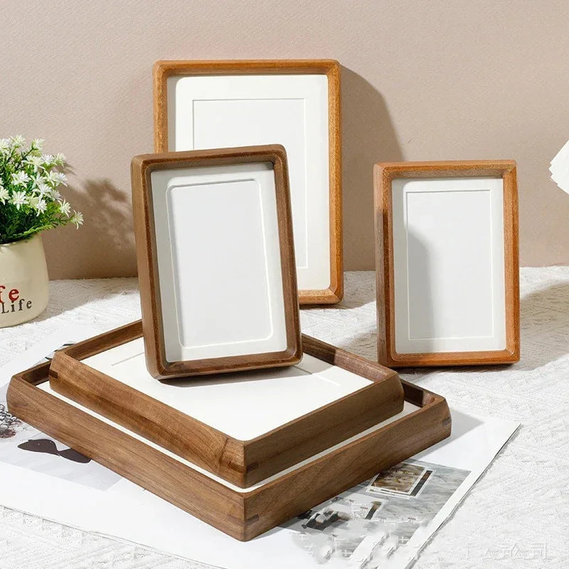 Four handcrafted solid wood photo frames in various sizes, arranged on a white cloth.