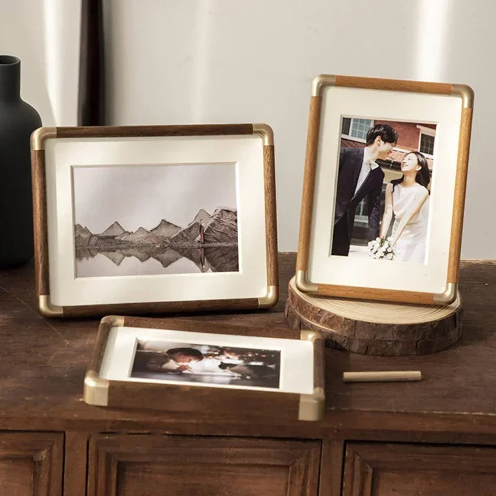Three Brooks Vintage Photo Frames with wood and brass accents on a wooden surface.