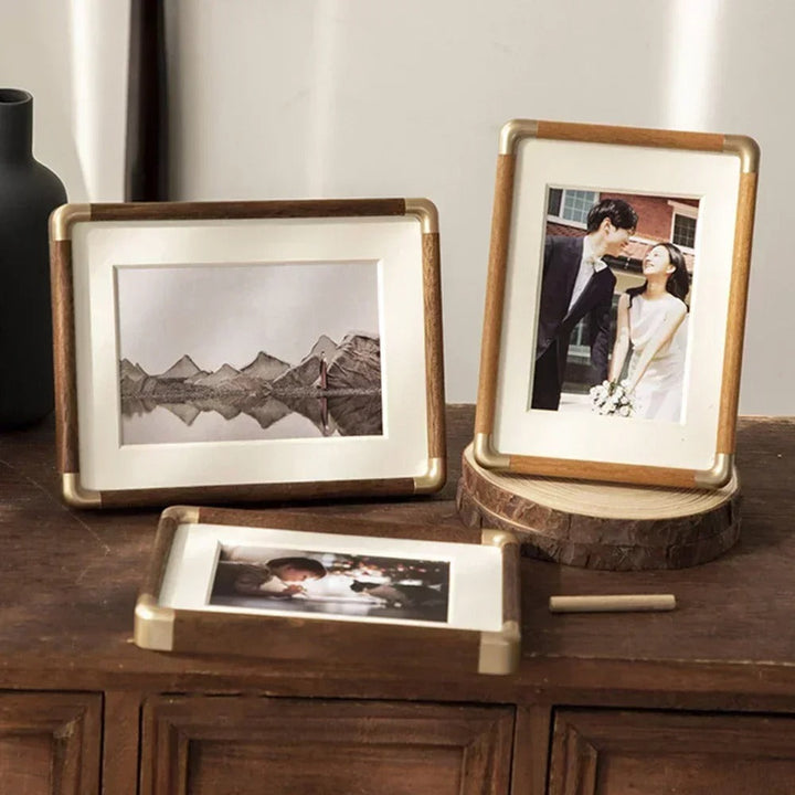 Three Brooks Vintage Photo Frames with wood and brass accents on a wooden surface.