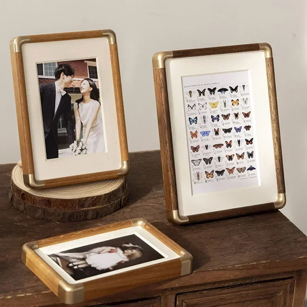 Three Brooks Vintage Photo Frames with wood and brass details display a wedding photo, a butterfly chart, and a child&