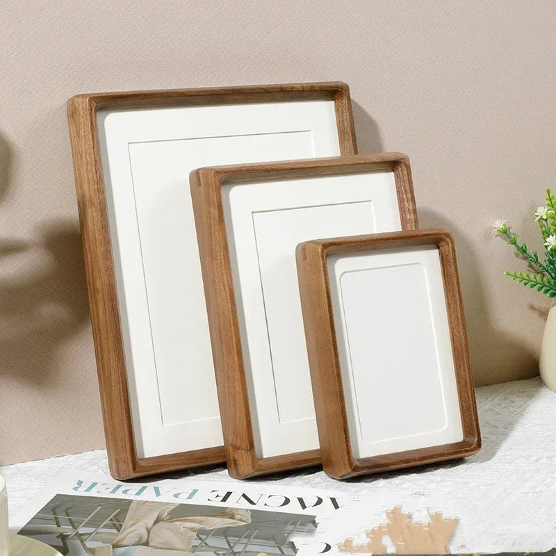 Three handcrafted solid wood photo frames with natural finish in varying sizes, displayed on a surface.