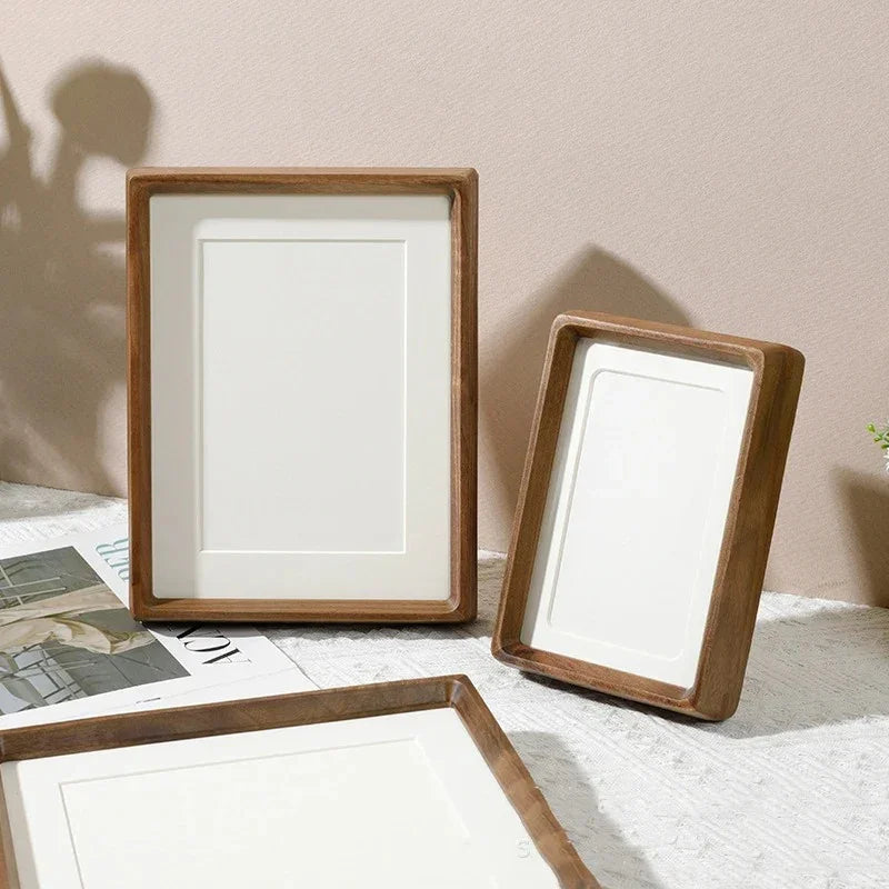 Three handcrafted solid wood photo frames with natural finish on a white surface.