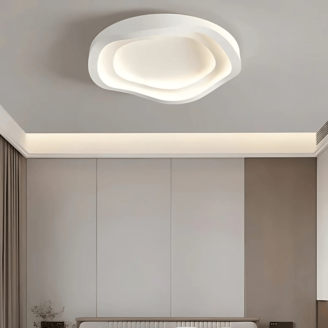 Modern white ceiling light with layered, organic shape and integrated LED illumination.
