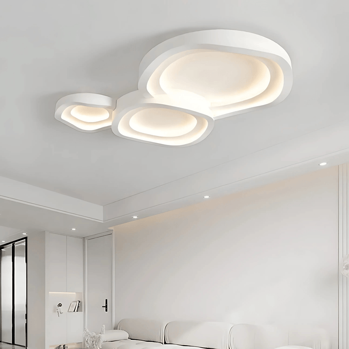 Modern white ceiling light with layered, organic shapes and integrated LED illumination.