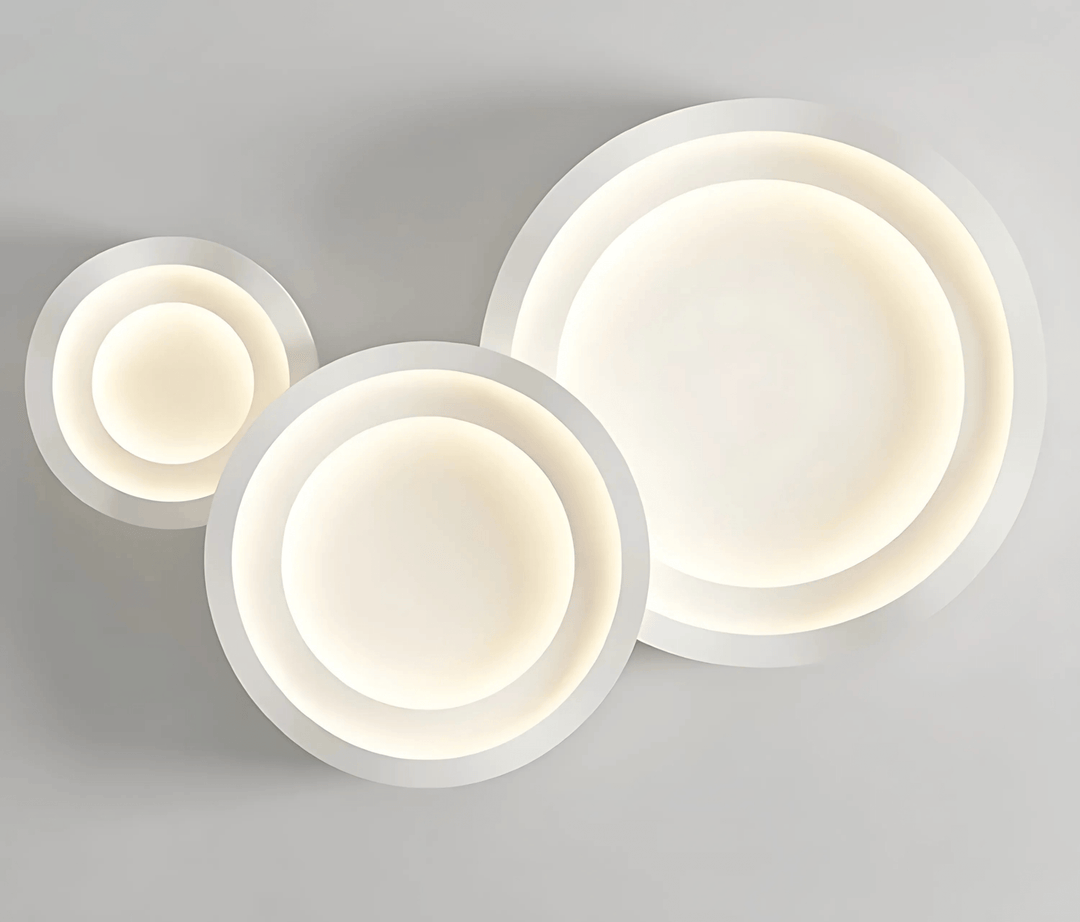 Three concentric white circles with soft, warm light emanating from the center, mounted on a gray background.