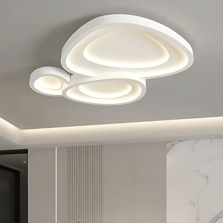 Modern white ceiling light with overlapping organic shapes and integrated LED illumination.