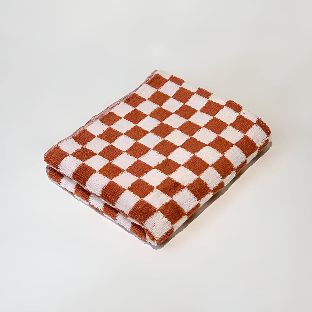 Red and white checkered cotton towel folded on a white surface.