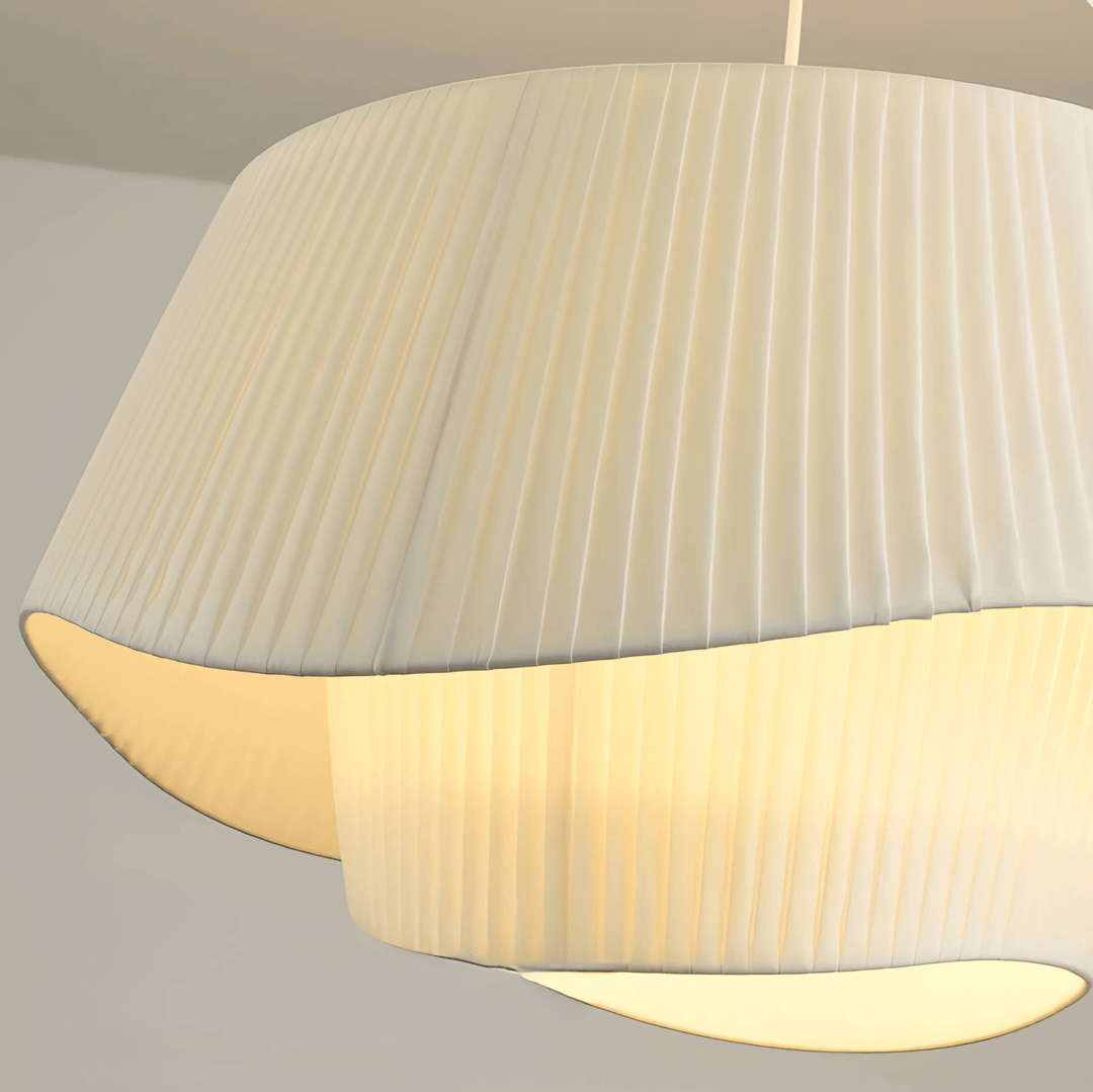 Pleated cream pendant light with warm ambient glow from within.