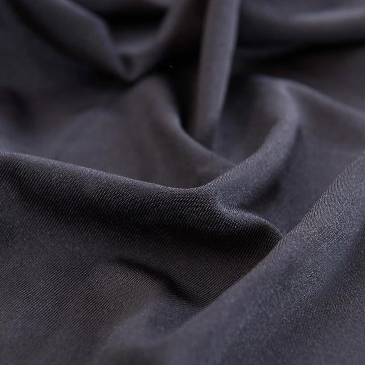 Black adaptable couch cover made of soft micro-fabric with a non-slip finish.