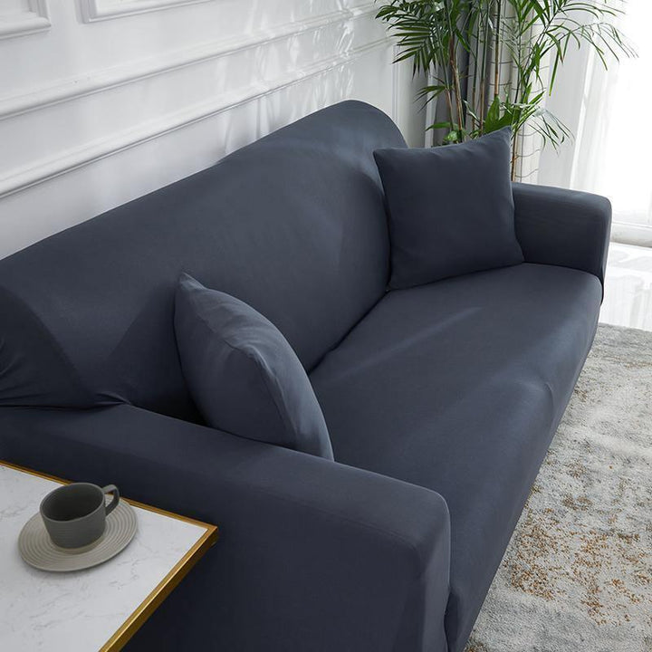 Clay grey adaptable couch cover on a sofa with two throw pillows.