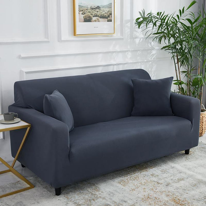 Clay grey adaptable couch cover on a sofa with two throw pillows.