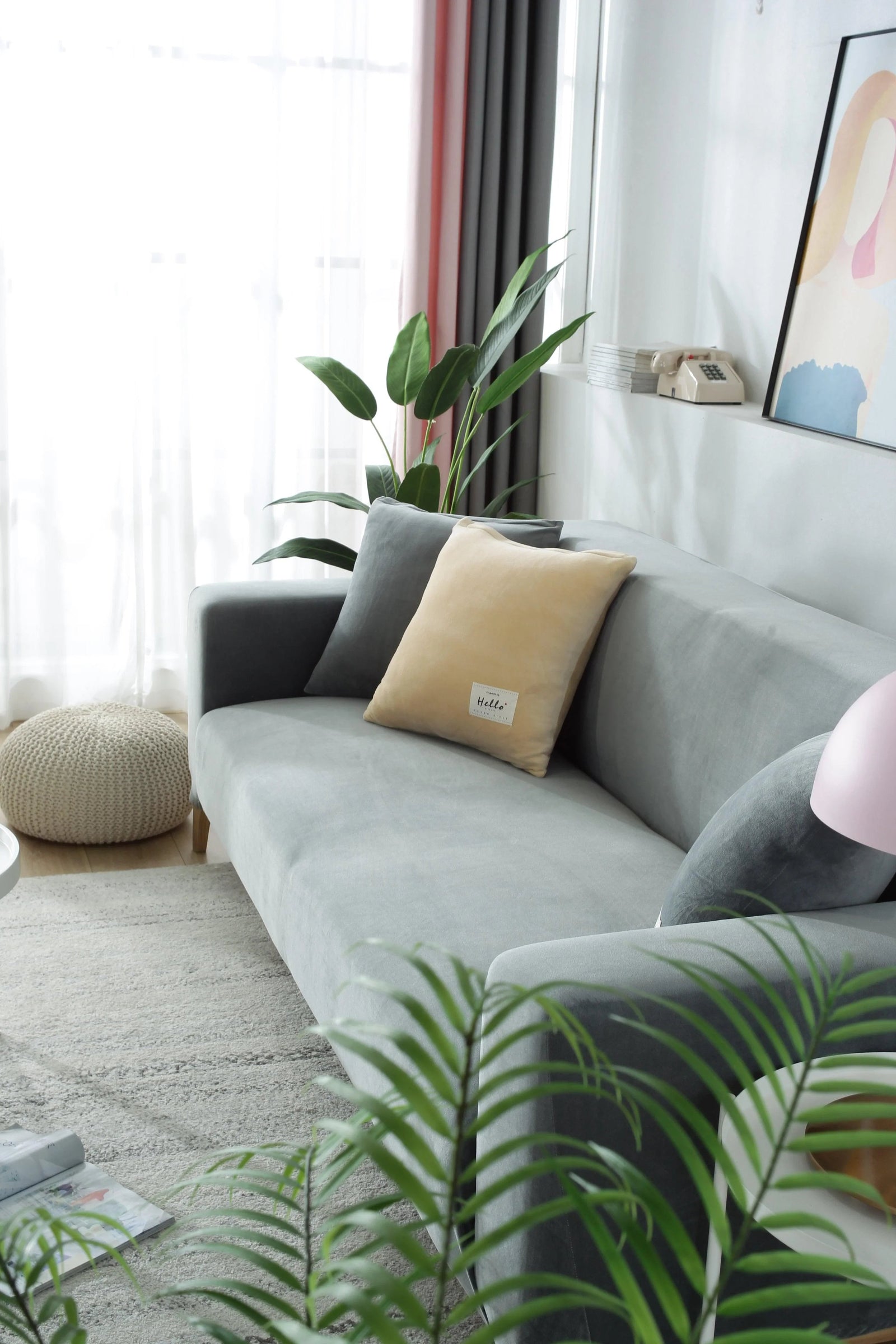 Light grey velvet couch cover draped over a sofa with decorative pillows.