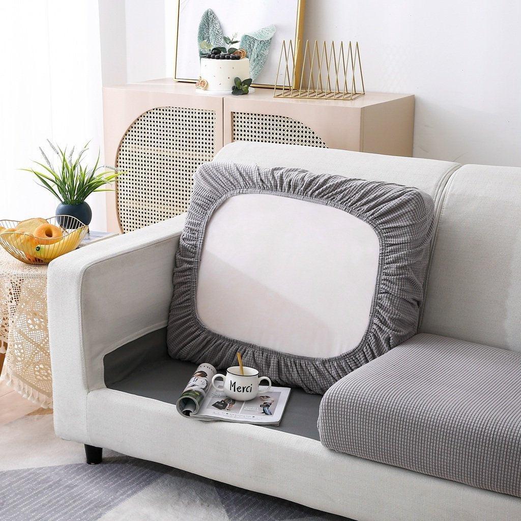 Light grey narrow jacquard sofa cushion cover with a textured weave on a sofa.
