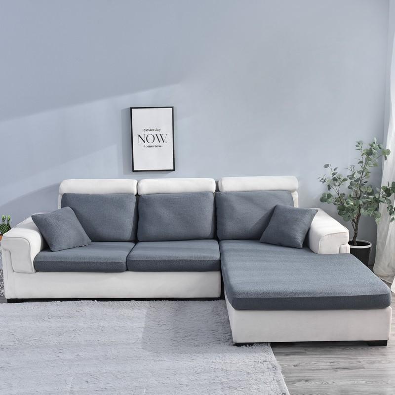Dark grey waterproof sofa cushion cover on a sectional sofa with white upholstery.