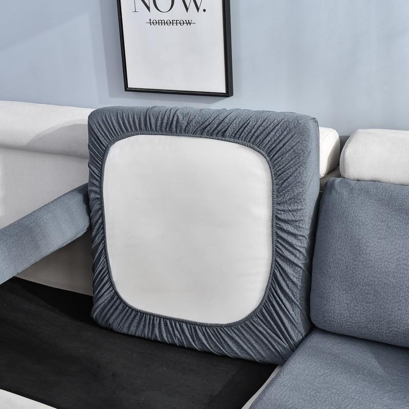 Dark grey waterproof sofa cushion cover with a white center, fitting snugly over a sofa cushion.