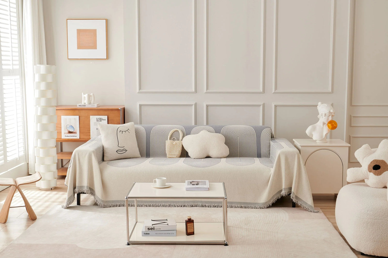 Dusty grey chenille throw blanket draped over a sofa with decorative pillows and a coffee table.