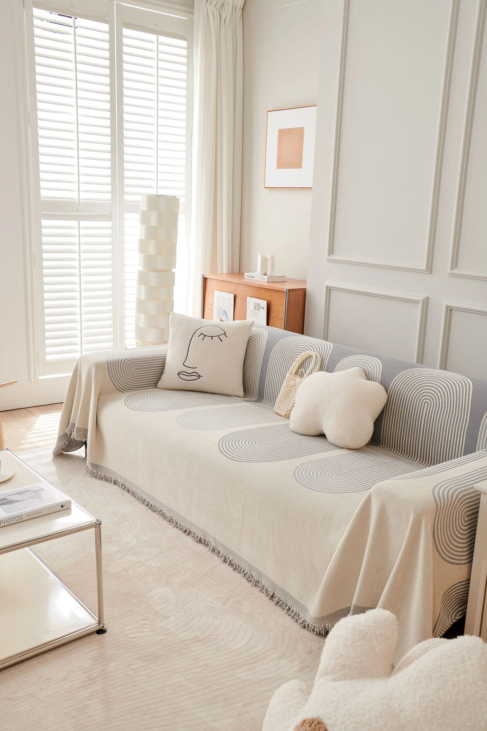 Dusty grey chenille throw blanket with a geometric pattern draped over a sofa.