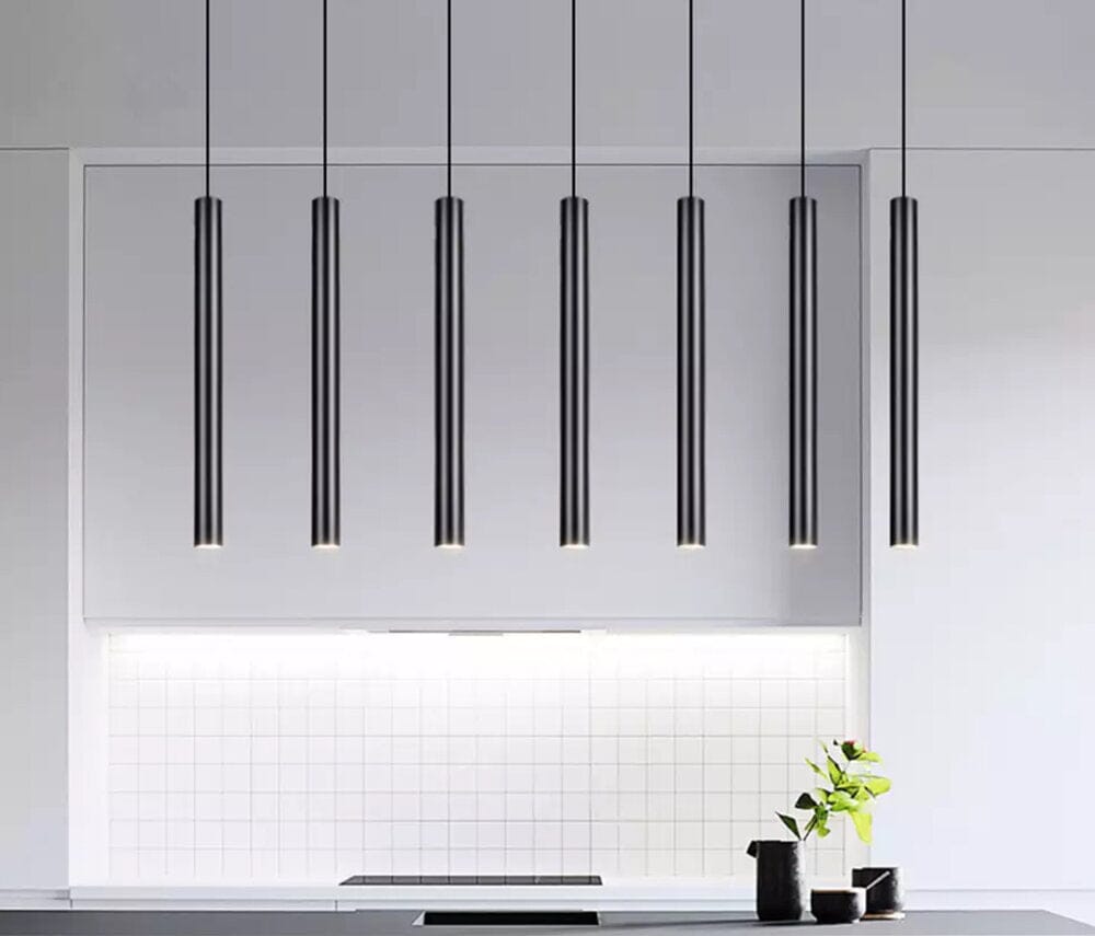 Modern black tube cluster pendant light hanging over a kitchen counter.